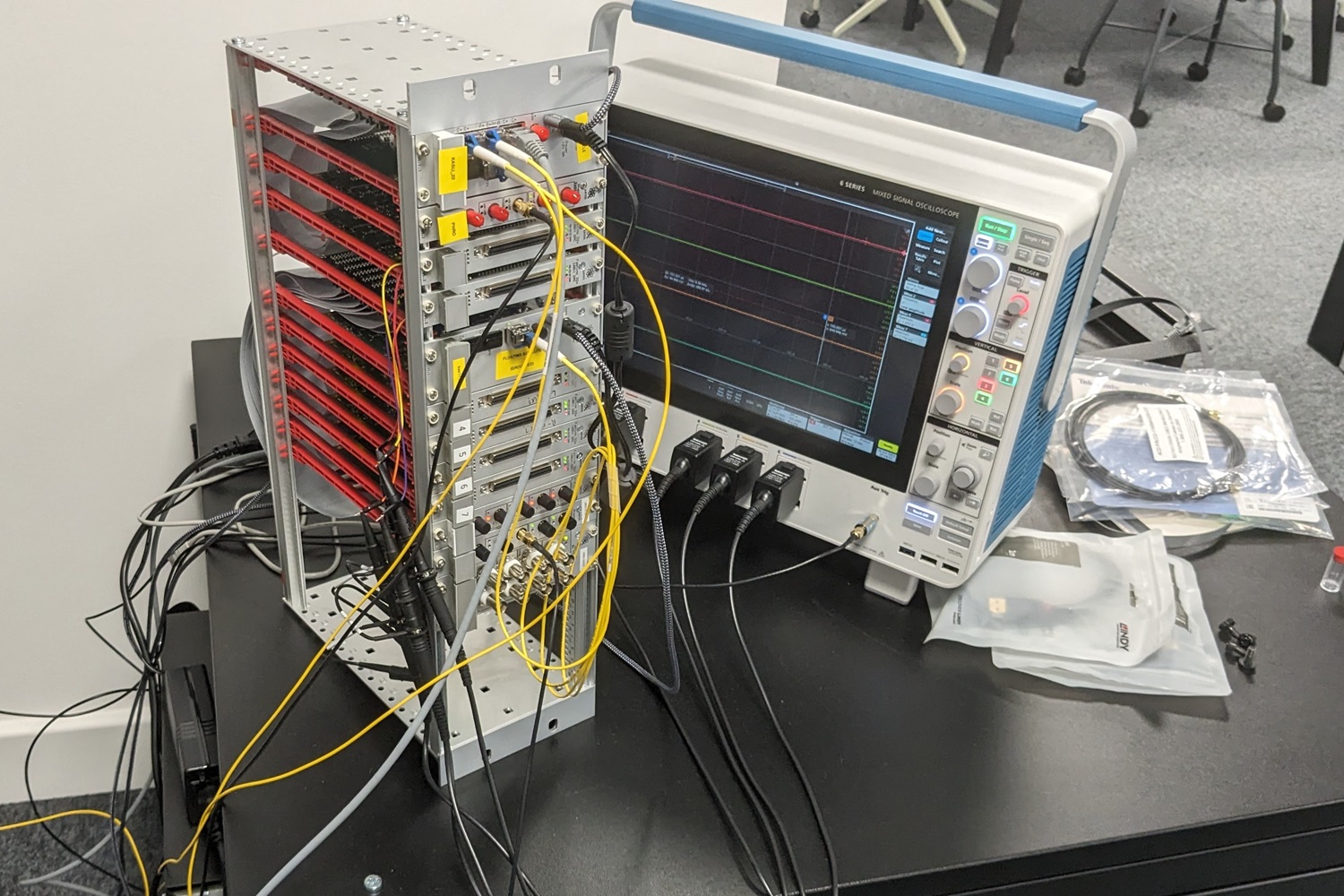 A rack of electronic equipment attached to an oscilloscope.